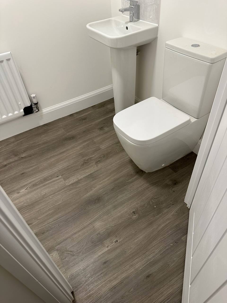 Grey wood-effect plank floor in a cloakroom WC