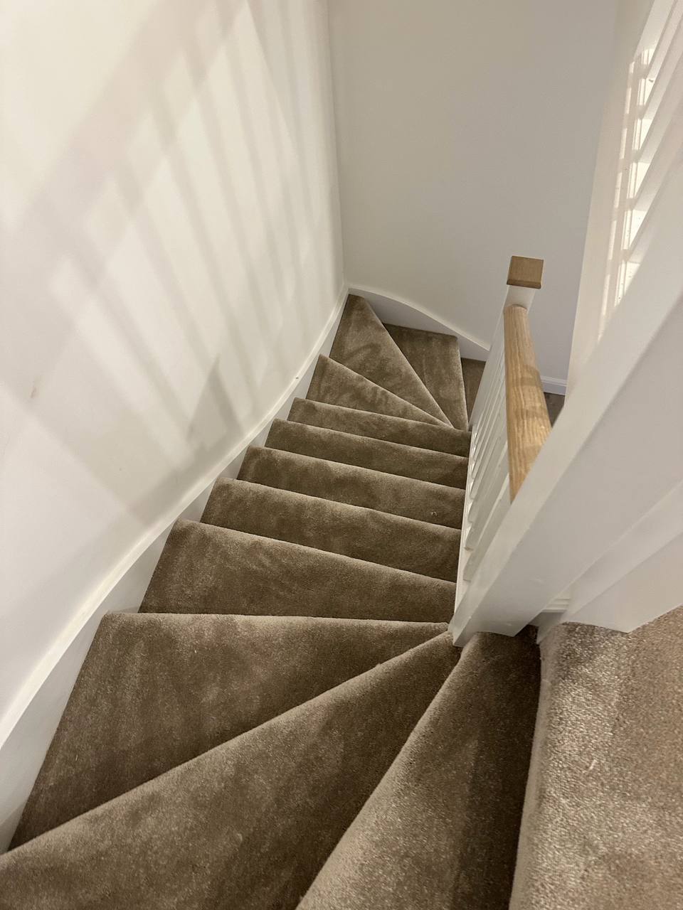 Carpeted winder staircase seen from the top
